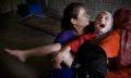 August, 25, 2008. Tuz Khurmatu, northern Iraq, a midwife slices part of seven year-old Sheelan Anwar Omer's genitals. The midwife also delivered Omer and is a trusted and valued member of the neighborhood. Sheelan's mother, right, holds her. Photographer: Andrea Bruce.[28]